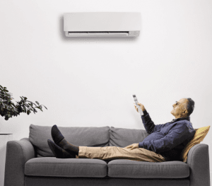 person on couching turning ductless system on