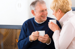 couple smiling over mugs
