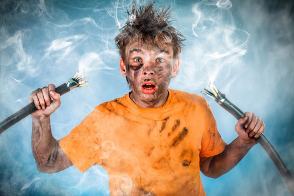 person holding smoking electrical wires