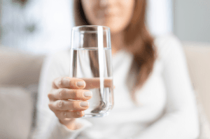 person holding glass of water