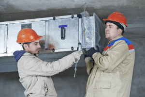 two technicians installing HVAC system