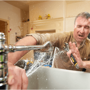 broken faucet spraying man with water