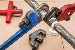 two wrenches repairing a metal pipe