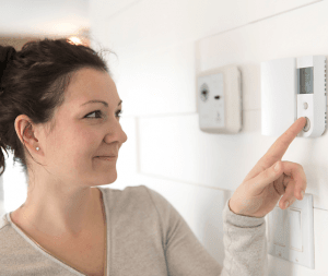 woman adjusting thermostat