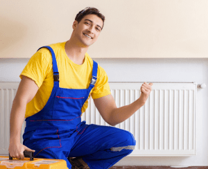 hvac technician in front of wall heater giving thumbs up
